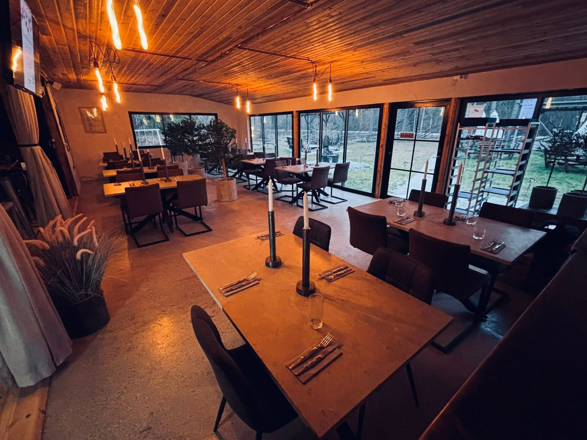 Restaurangen inomhus med långbord och stora fönster